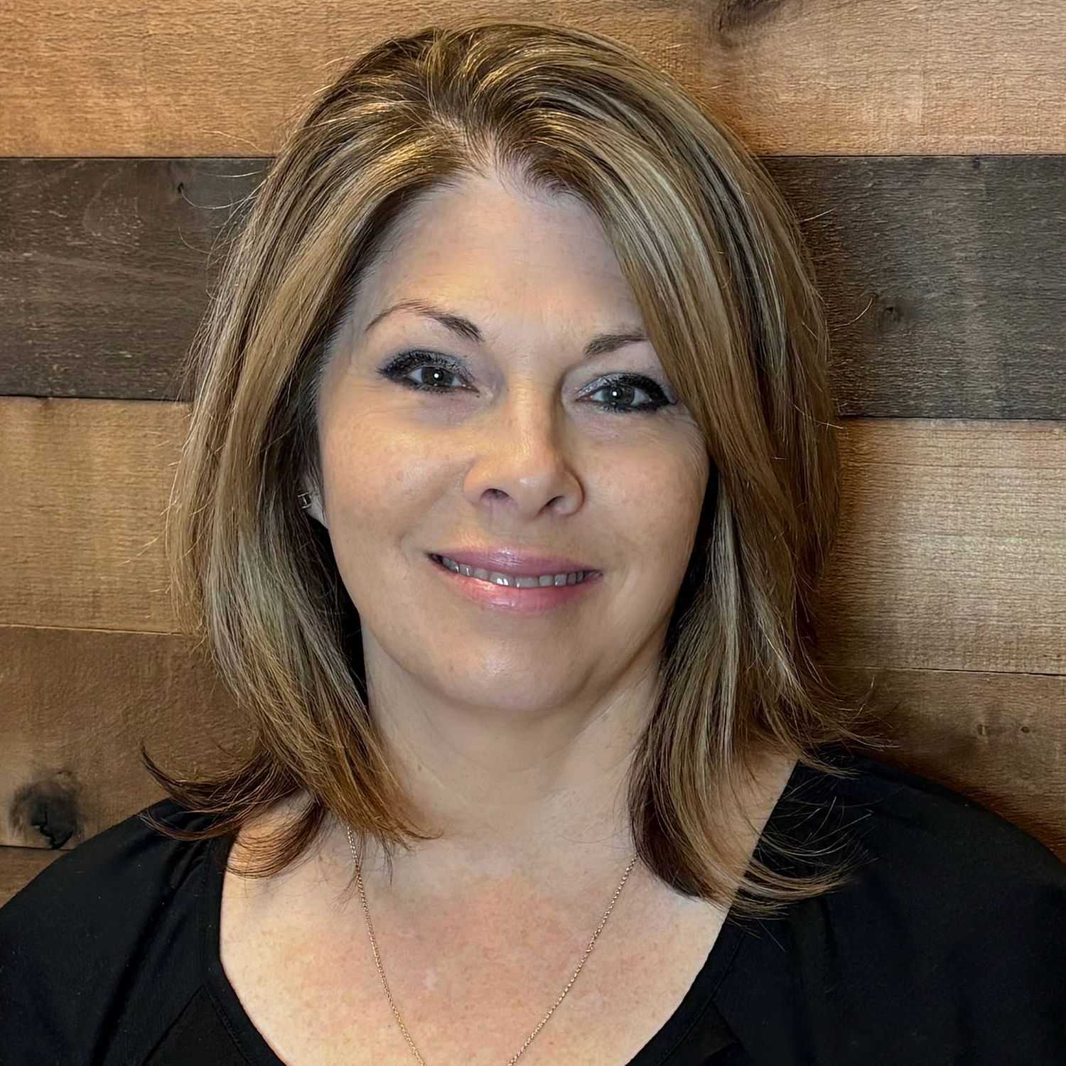 Portrait of Kim C, a professional stylist at Laschi Hairstylists & Day Spa, showcasing their expertise and style.